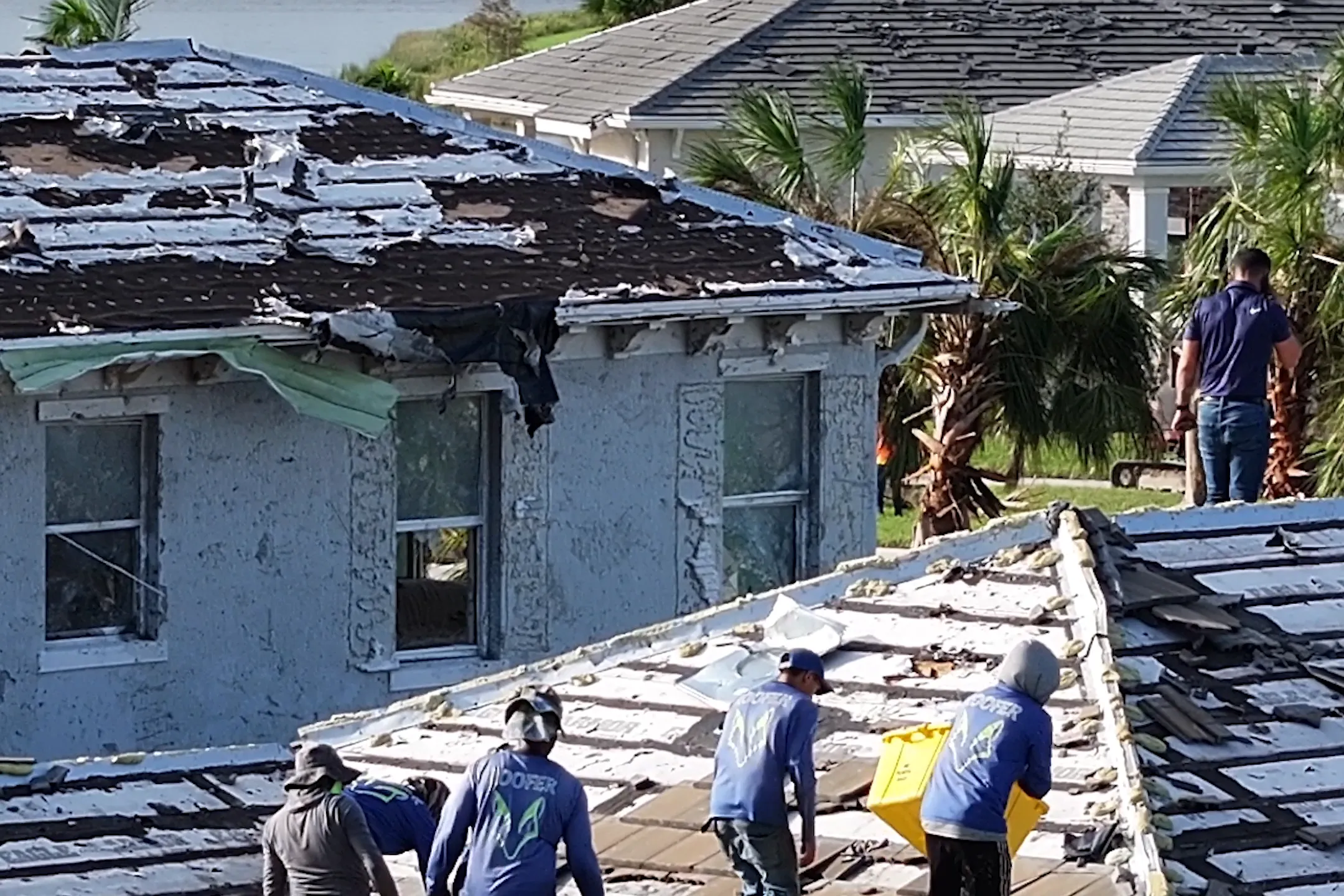 A roofing crew stripping a storm damaged tile roof in Avenir, Palm Beach Gardens, after Hurricane Milton