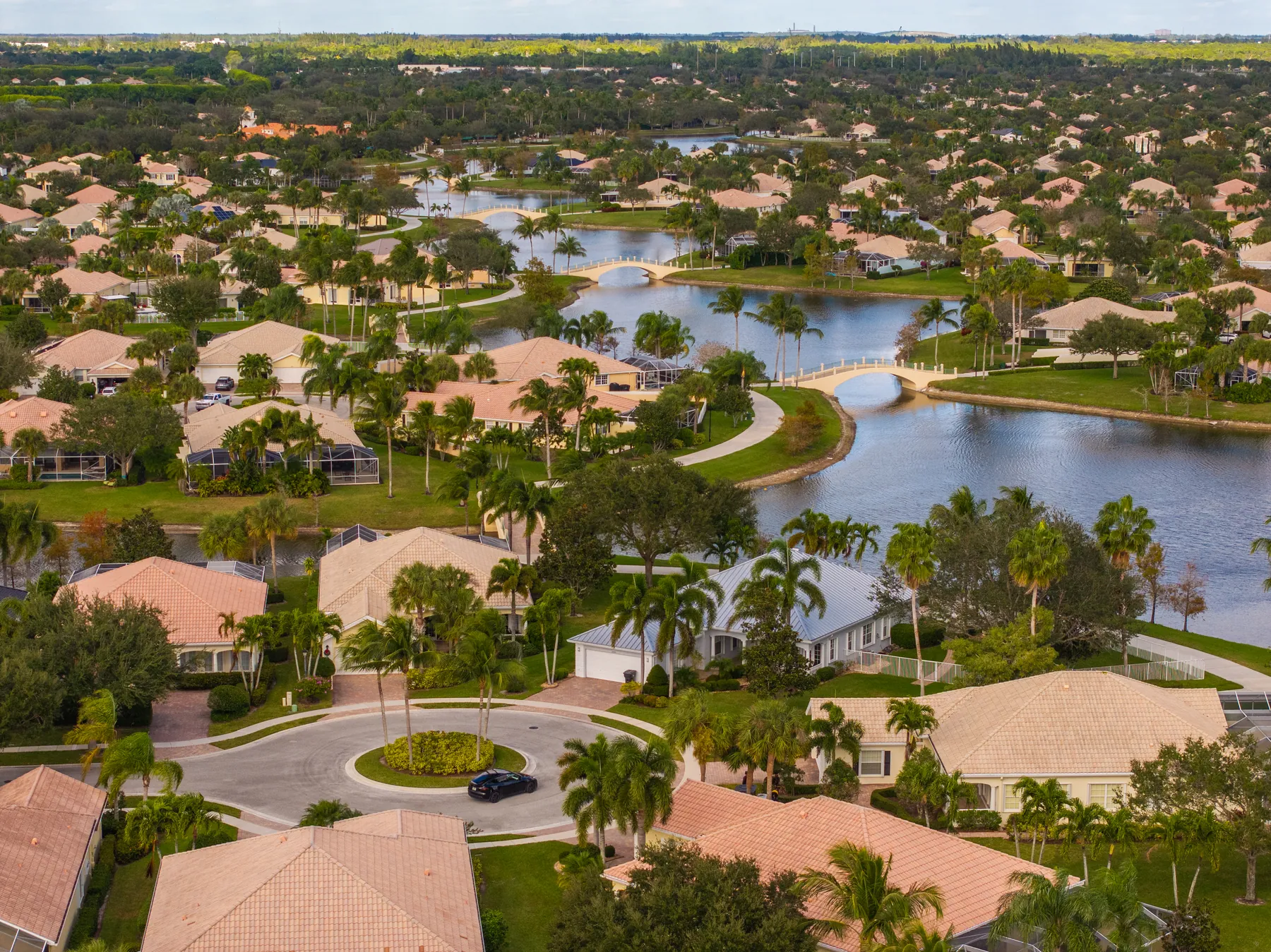 Aerial view of a Treasure Coast neighborhood with tile roofs, lakes and palm trees