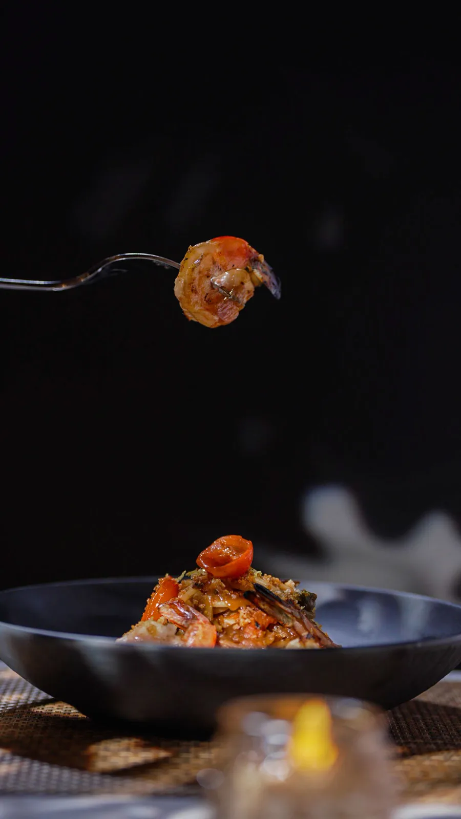 A forkful of shrimp lifted over the plate