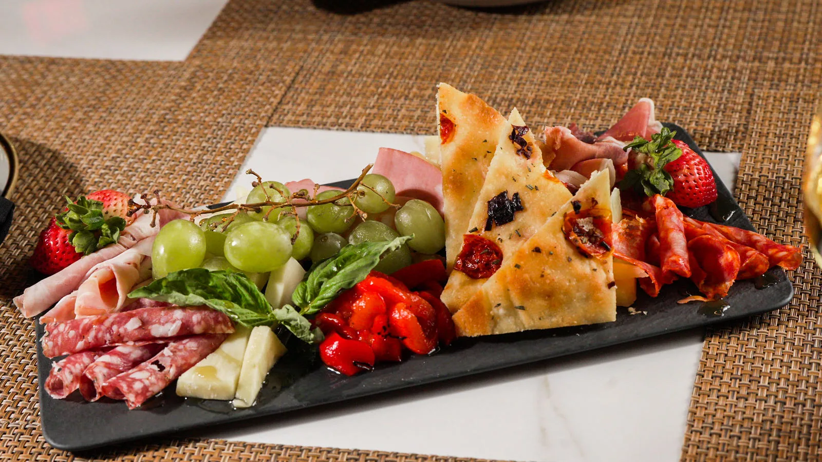 An antipasto board of cured meats, cheese and fruit