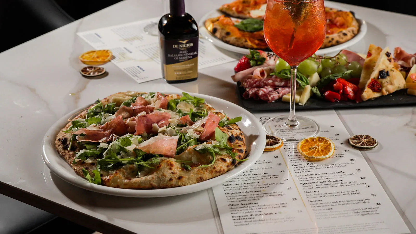 Prosciutto and arugula pizza with a spritz