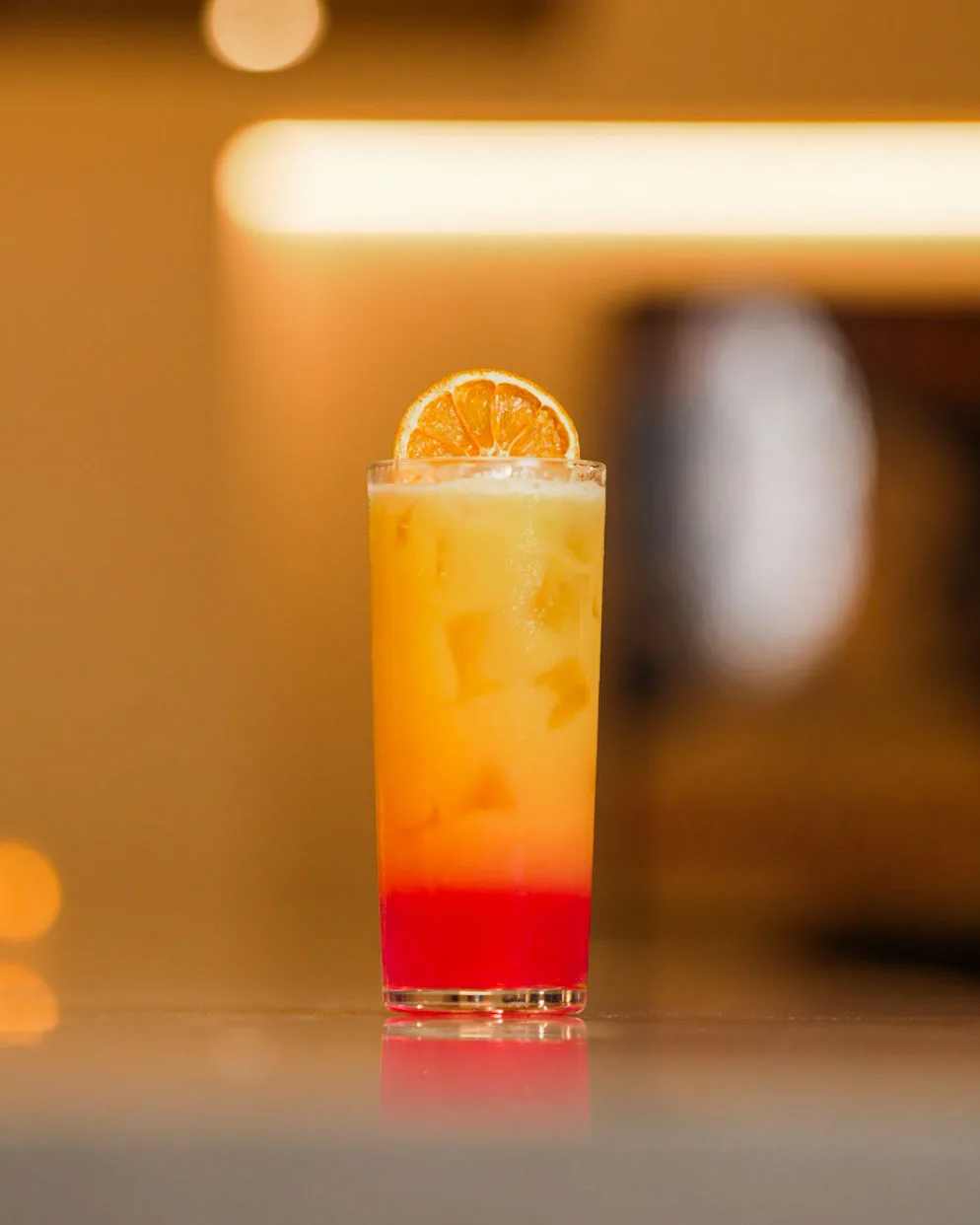 A layered orange and red cocktail
