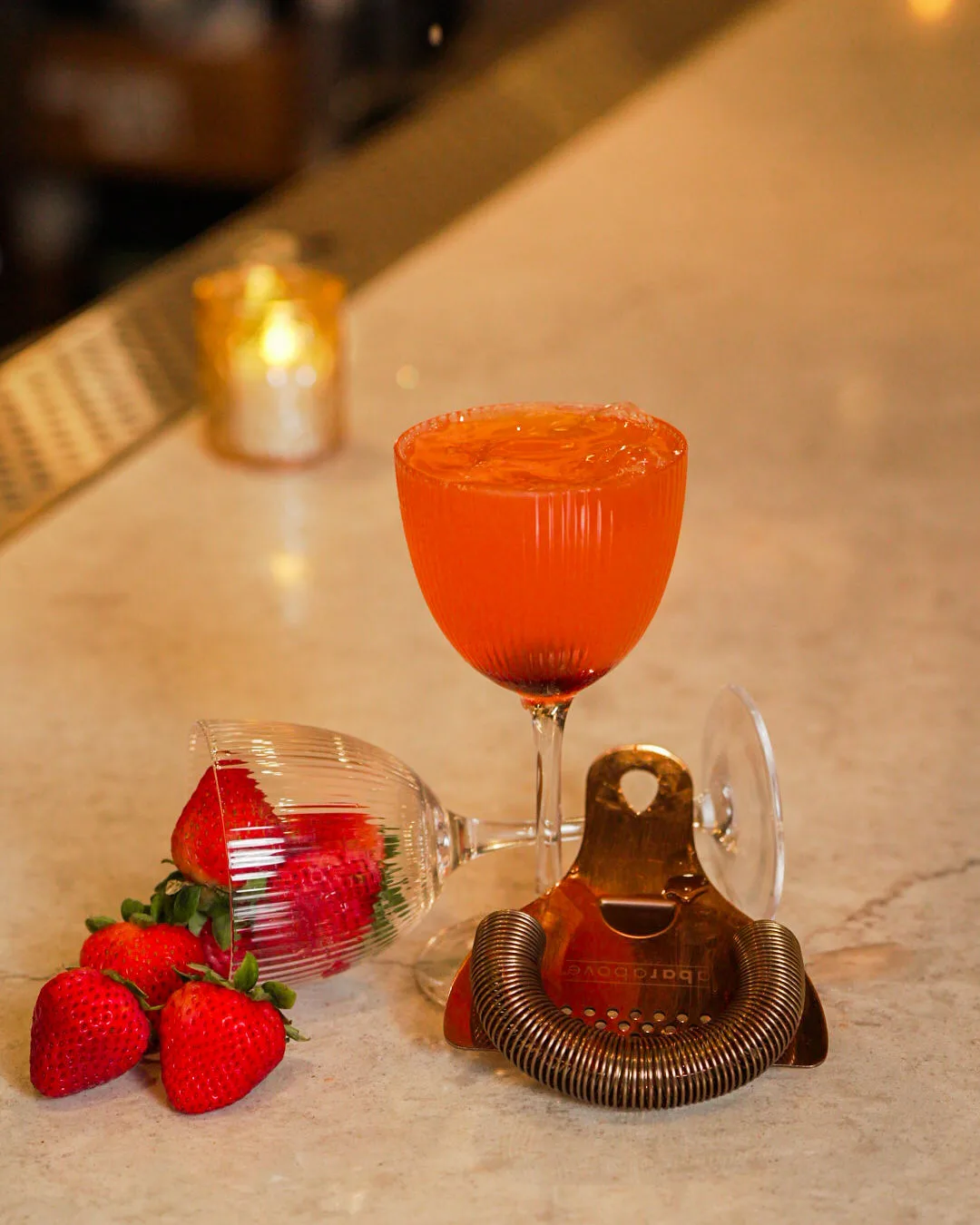 A red cocktail with strawberries
