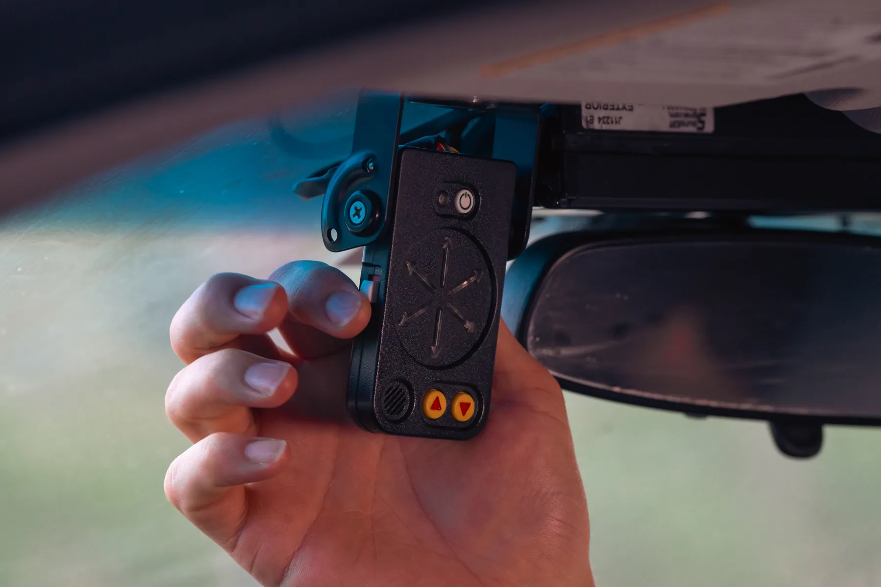 A hand swiveling the StopAmbush display, its arrows lit in red